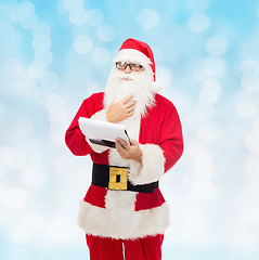 Image showing man in costume of santa claus with notepad