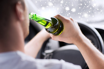 Image showing close up of man drinking alcohol while driving car