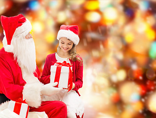 Image showing smiling little girl with santa claus and gifts