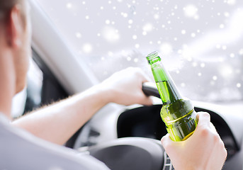 Image showing close up of man drinking alcohol while driving car