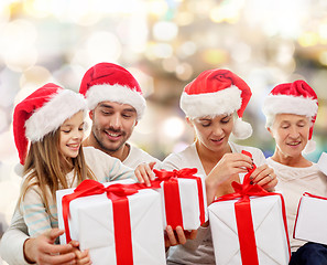 Image showing happy family in santa helper hats with gift boxes