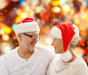 Image showing happy senior couple in santa helper hats