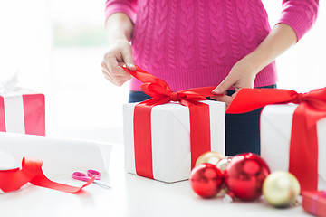 Image showing close up of woman decorating christmas presents