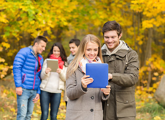 Image showing group of smiling friends with tablets in park