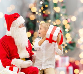 Image showing smiling little boy with santa claus and gifts