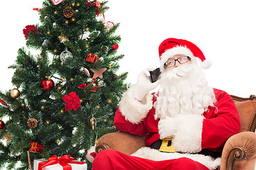 Image showing santa claus with smartphone and christmas tree