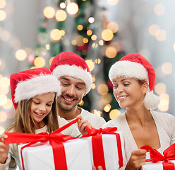 Image showing happy family in santa helper hats with gift boxes