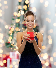 Image showing smiling woman holding red gift box