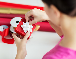 Image showing close up of woman decorating christmas presents