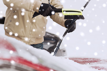 Image showing closeup of man cleaning snow from car