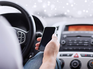 Image showing close up of man using smartphone while driving car