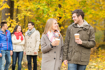 Image showing group of smiling friend with coffee cups in park