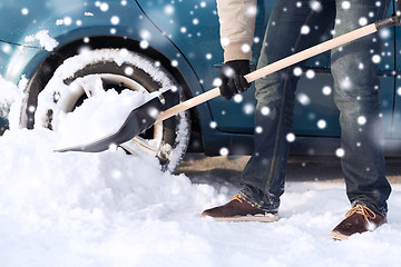 Image showing closeup of man digging snow with shovel near car