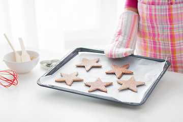 Image showing close up of woman with cookies on oven tray