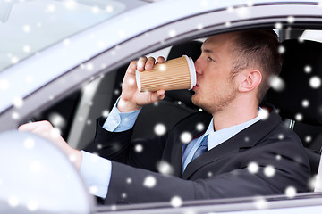 Image showing close up of man drinking coffee while driving car