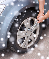 Image showing man changing tire