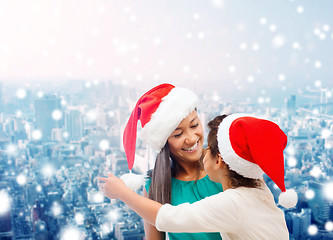 Image showing happy mother and girl in santa hats