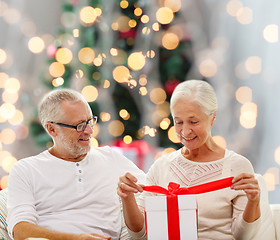 Image showing happy senior couple with gift box at home