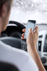 Image showing close up of man using smartphone while driving car
