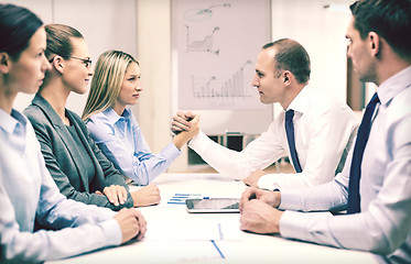 Image showing businesswoman and businessman arm wrestling