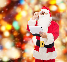 Image showing man in costume of santa claus with notepad