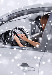 Image showing close up of woman with smartphone driving car