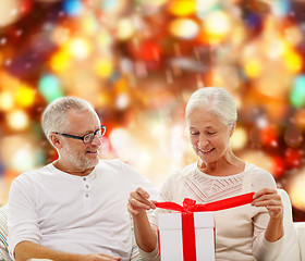 Image showing happy senior couple with gift box at home