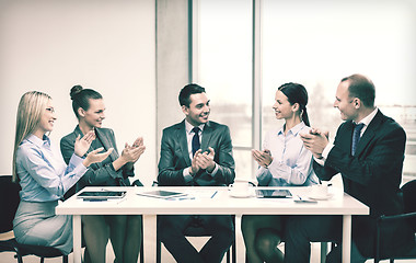 Image showing business team with laptop clapping hands