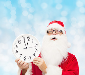 Image showing man in costume of santa claus with clock