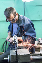 Image showing Senior worker grinds detail