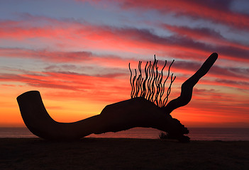 Image showing Sculpture by the Sea - Currawong silhouetted against sunrise sky