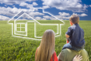 Image showing Young Family in Grass Field with Ghosted House in Front