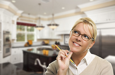 Image showing Daydreaming Woman with Pencil Inside Beautiful Custom Kitchen