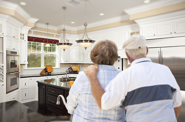 Image showing Senior Couple Looking Over Beautiful Custom Kitchen