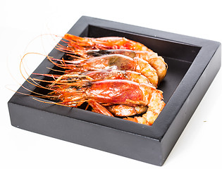 Image showing grilled shrimp in black plate on white background.