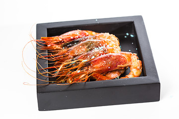 Image showing grilled shrimp in black plate on white background.