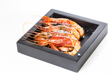 Image showing grilled shrimp in black plate on white background.