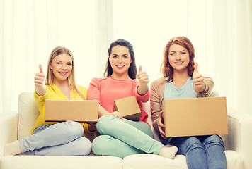 Image showing smiling teenage girls with cardboard boxes at home