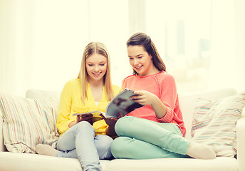 Image showing two girlfriends reading magazine at home