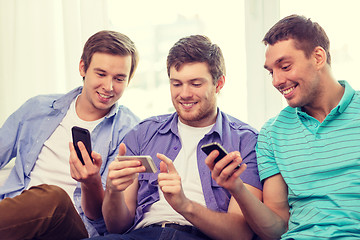 Image showing smiling friends with smartphones at home