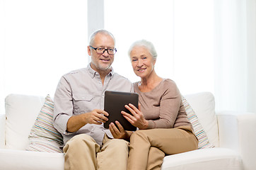 Image showing happy senior couple with tablet pc at home