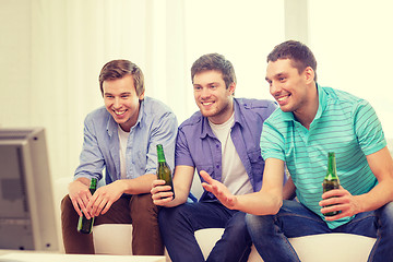 Image showing happy male friends with beer watching tv at home