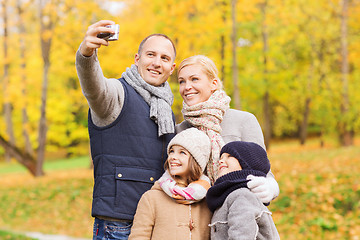 Image showing happy family with camera in autumn park