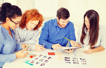 Image showing team with color samples and blueprint at office