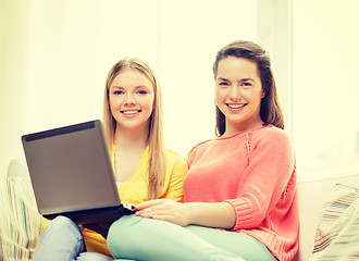 Image showing two smiling teenage girls with laptop at home