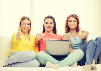 Image showing three smiling teenage girls with laptop at home