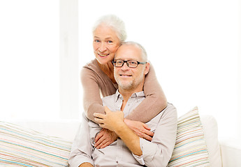 Image showing happy senior couple hugging on sofa at home