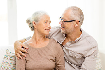 Image showing happy senior couple hugging on sofa at home