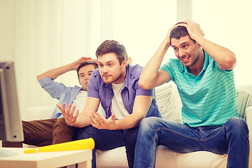 Image showing sad male friends with vuvuzela watching sports