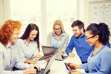 Image showing smiling team with laptop and table pc computers